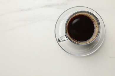 Photo of Cup of aromatic coffee on white table, top view. Space for text