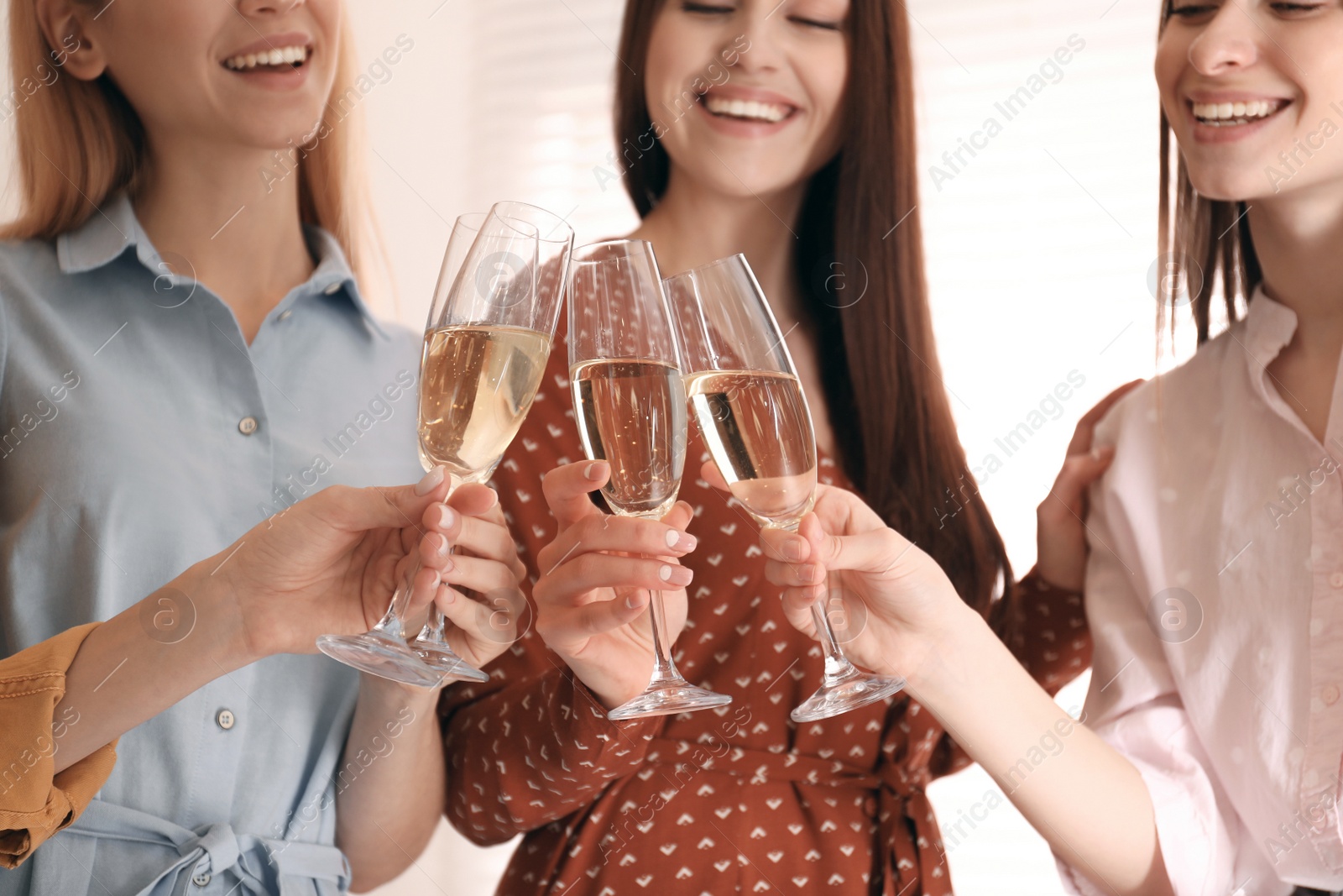 Photo of Young ladies clinking glasses of champagne, closeup. Women's Day