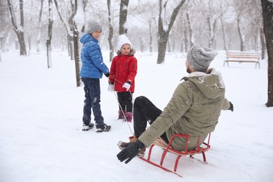 Photo of Father with his children spending time outside on winter day. Christmas vacation