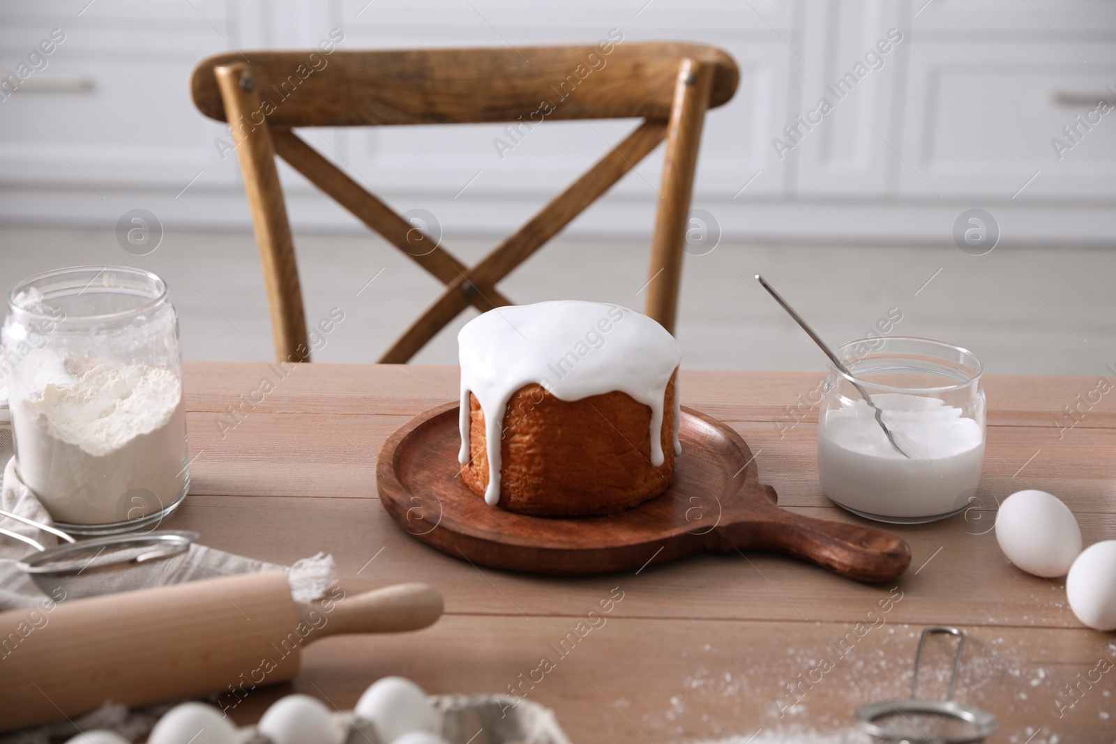 Photo of Traditional Easter cake and ingredients on table in kitchen