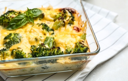 Photo of Tasty broccoli casserole in baking dish on table, closeup