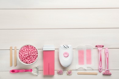 Set of epilation products on white wooden table, flat lay. Space for text