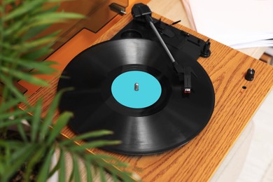 Photo of Stylish turntable with vinyl record indoors, above view