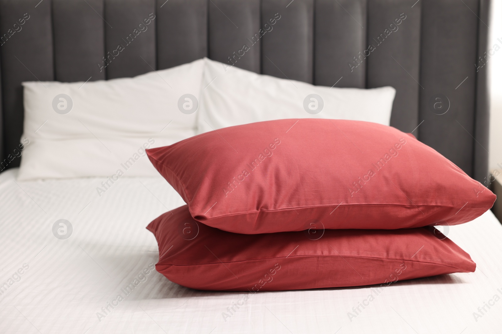 Photo of Soft pillows and striped bedsheet on bed. Space for text