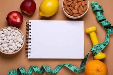 Photo of Measuring tape, notebook, fresh fruits and almonds on light brown background, flat lay. Low glycemic index diet