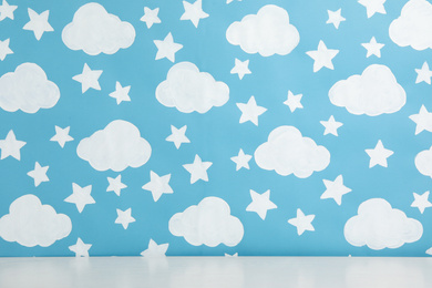 White table near wall with painted blue sky. Idea for baby room interior