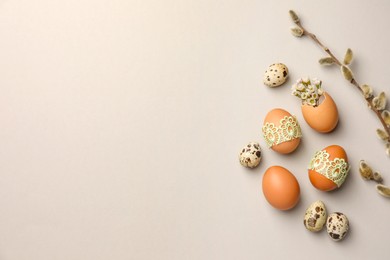 Photo of Flat lay composition with different eggs and natural decor on light grey background, space for text. Happy Easter