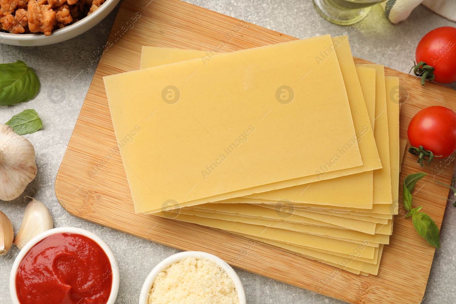 Photo of Flat lay composition with products for cooking lasagna on grey textured table