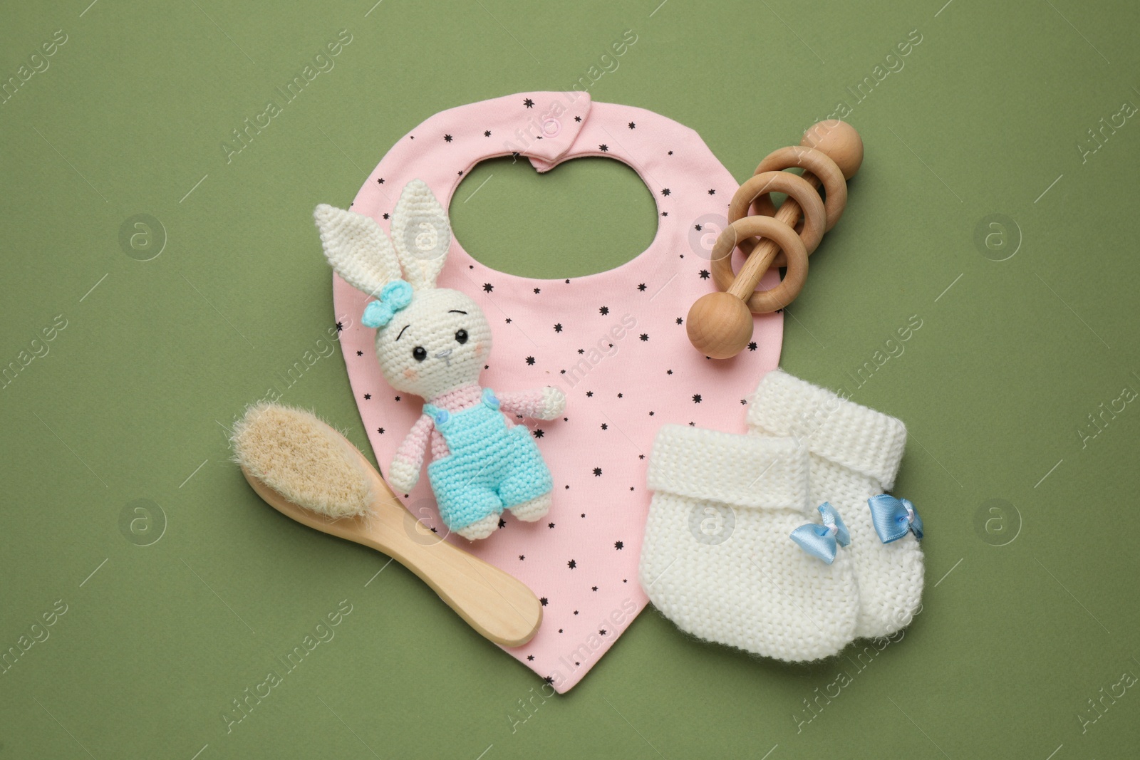 Photo of Flat lay composition with baby accessories and bib on green background