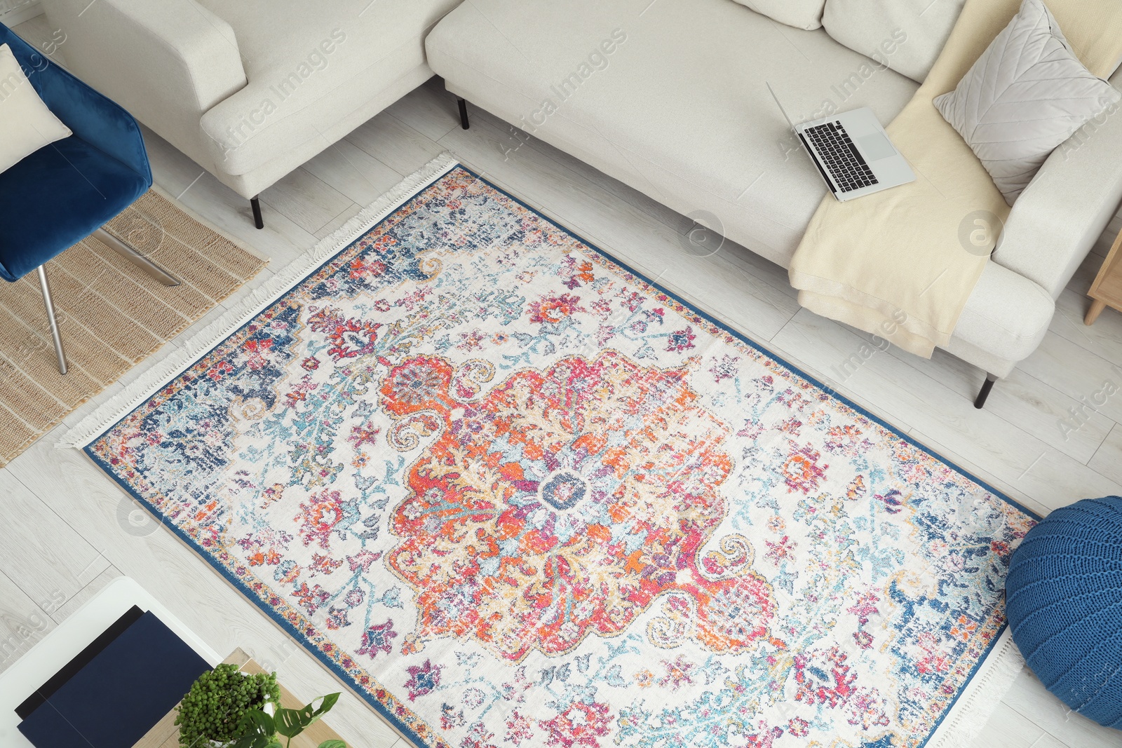 Photo of Stylish living room with beautiful carpet, comfortable sofa and pouf, above view. Interior design