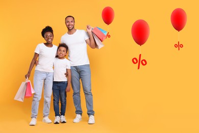 Image of Discount offer. Happy family with paper shopping bags on orange background. Balloons with percent signs near them