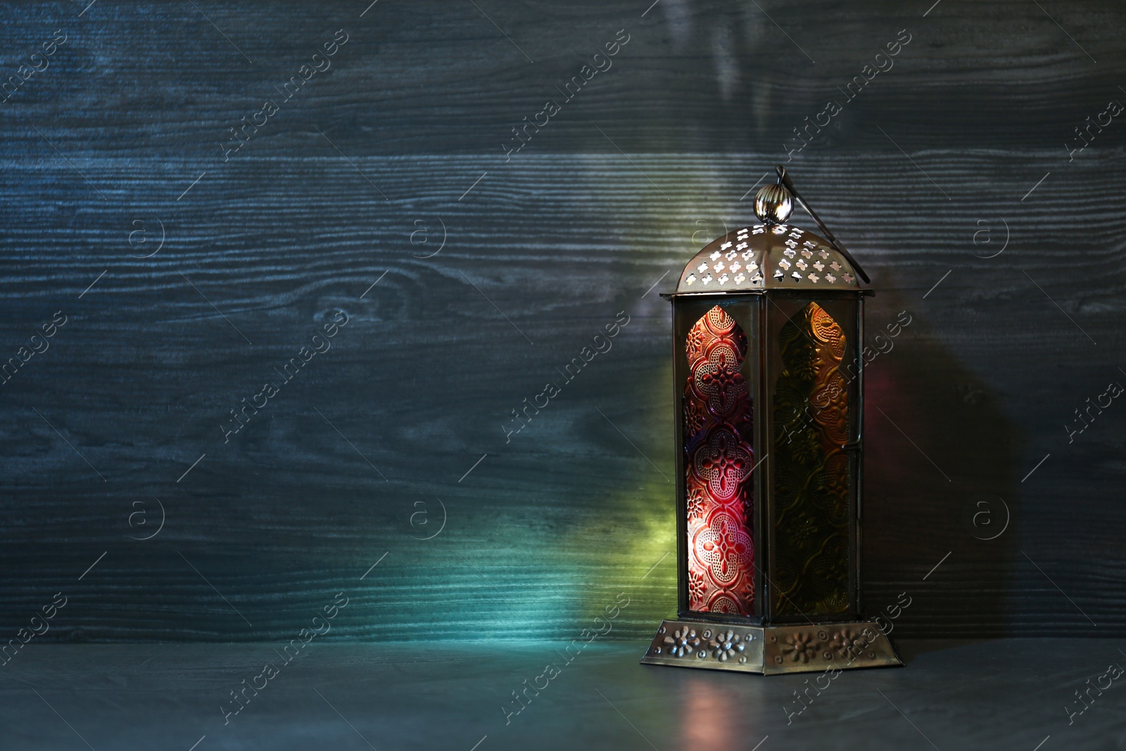 Photo of Decorative Arabic lantern on grey table. Space for text