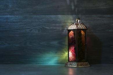 Photo of Decorative Arabic lantern on grey table. Space for text