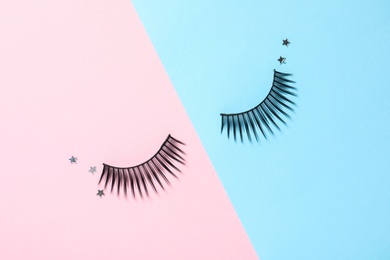 Photo of False eyelashes and sparkles on color background, flat lay