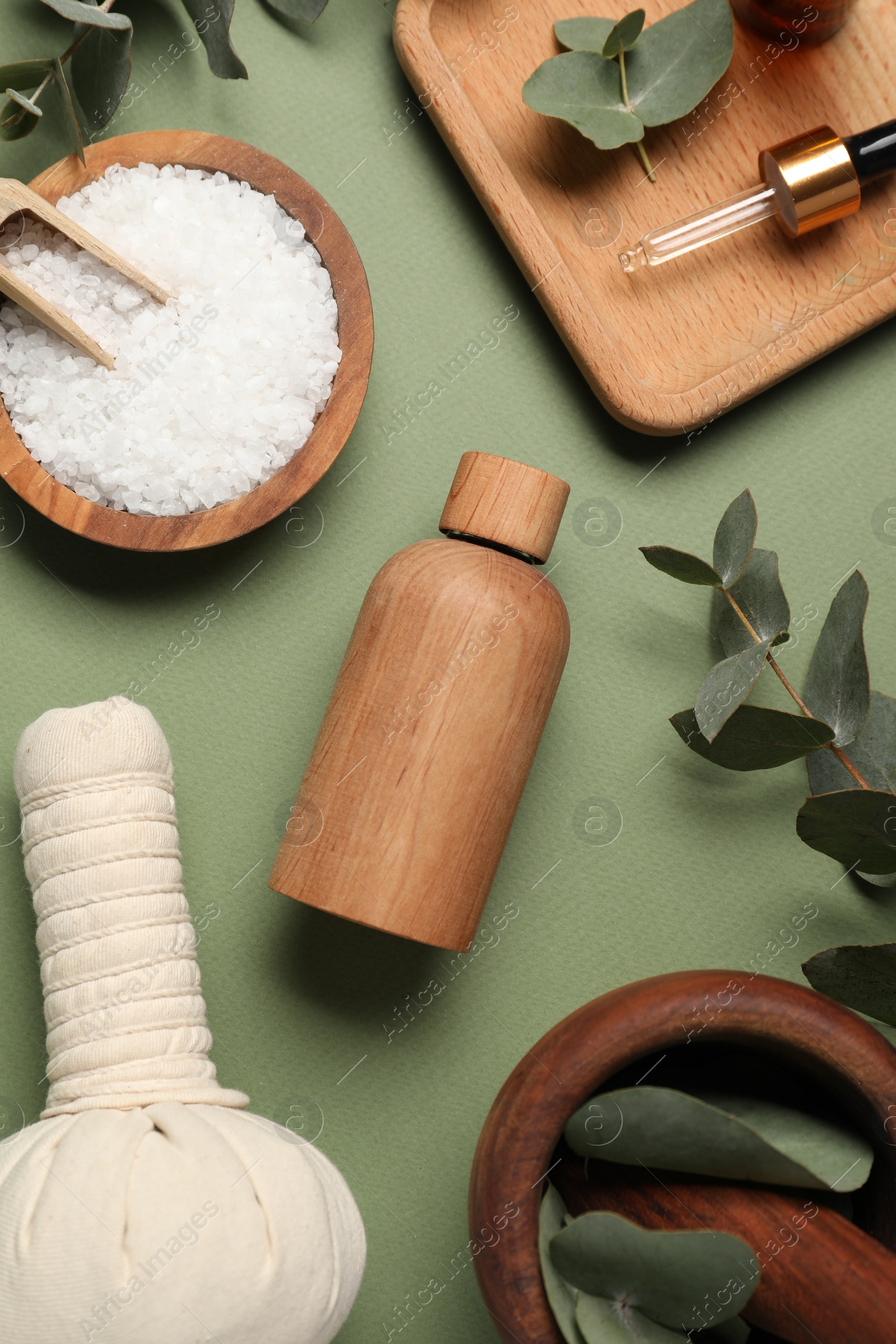 Photo of Different aromatherapy products and eucalyptus leaves on olive background, flat lay