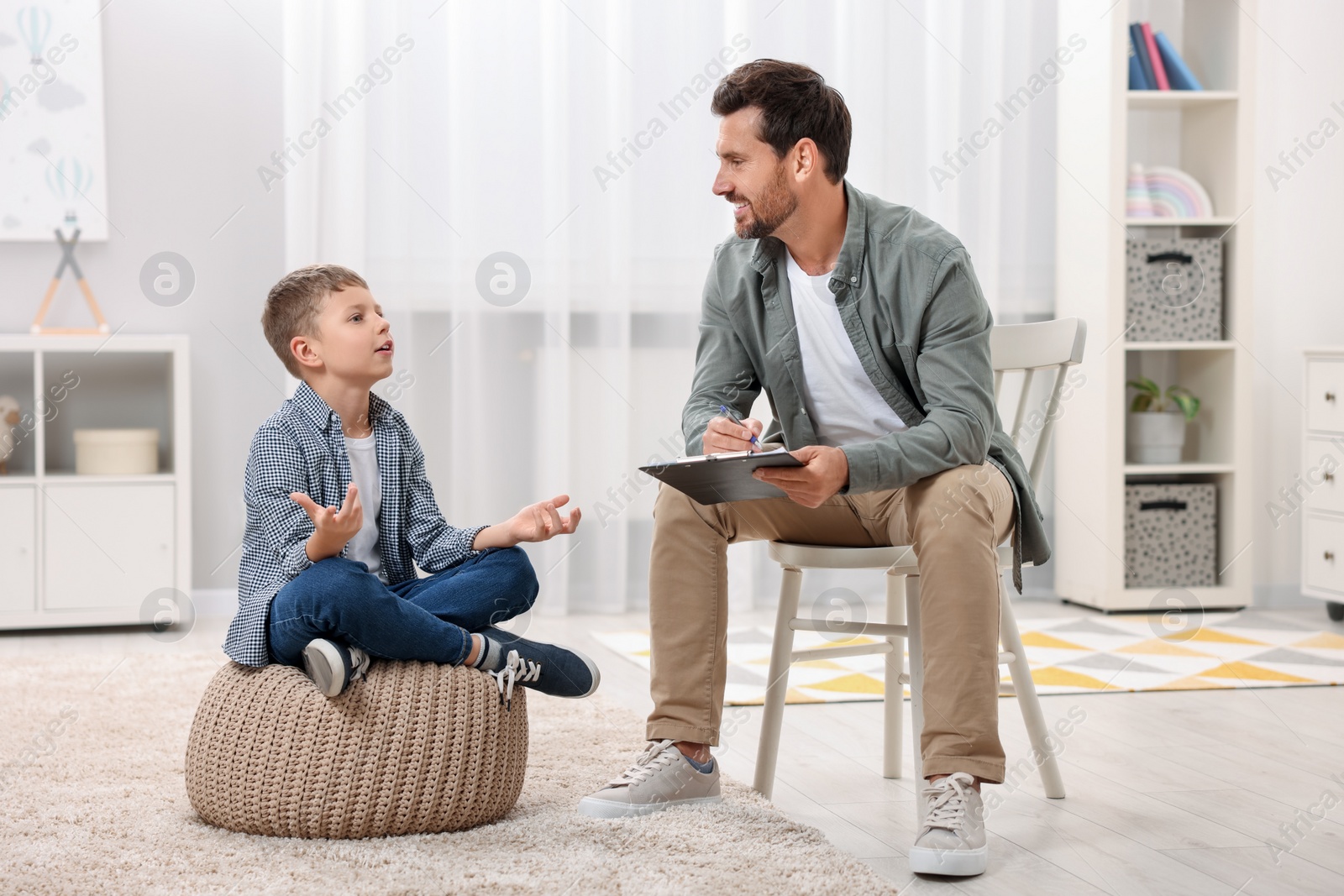 Photo of Dyslexia treatment. Therapist working with boy in room