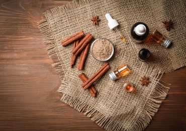 Photo of Composition with bottles of cinnamon oil on wooden background