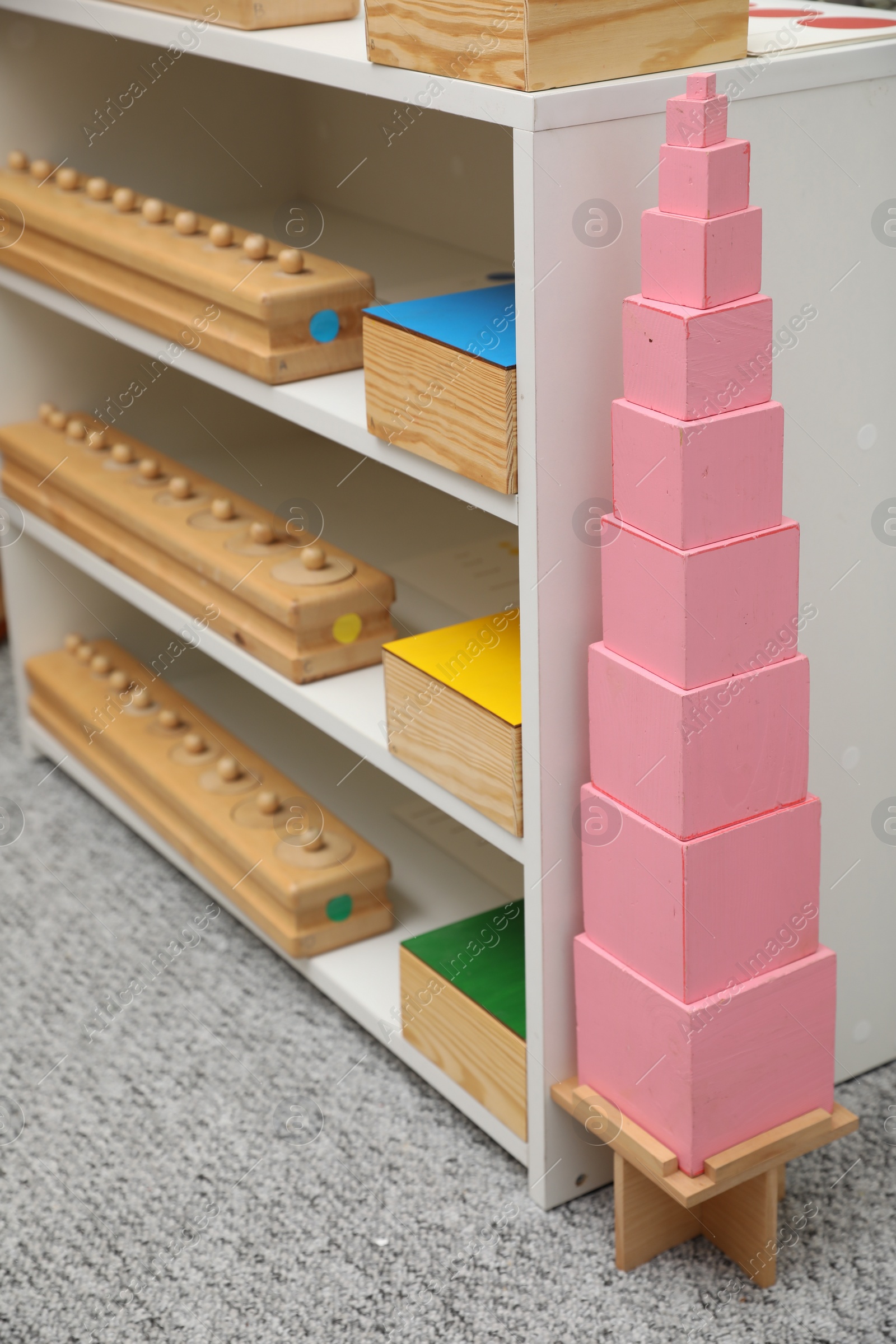 Photo of Shelving unit with different montessori toys in room