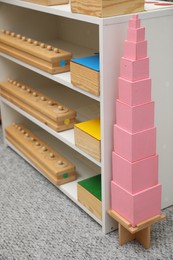 Photo of Shelving unit with different montessori toys in room