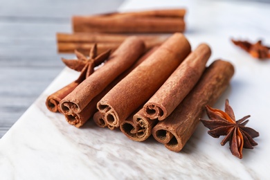 Photo of Aromatic cinnamon sticks and anise on marble board