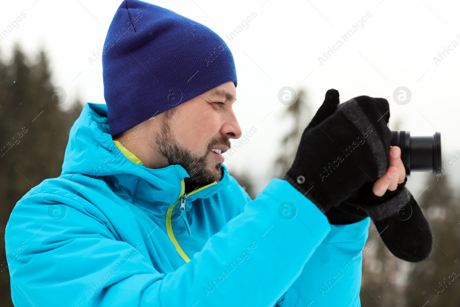 Photo of Man taking photo with camera outdoors. Winter vacation