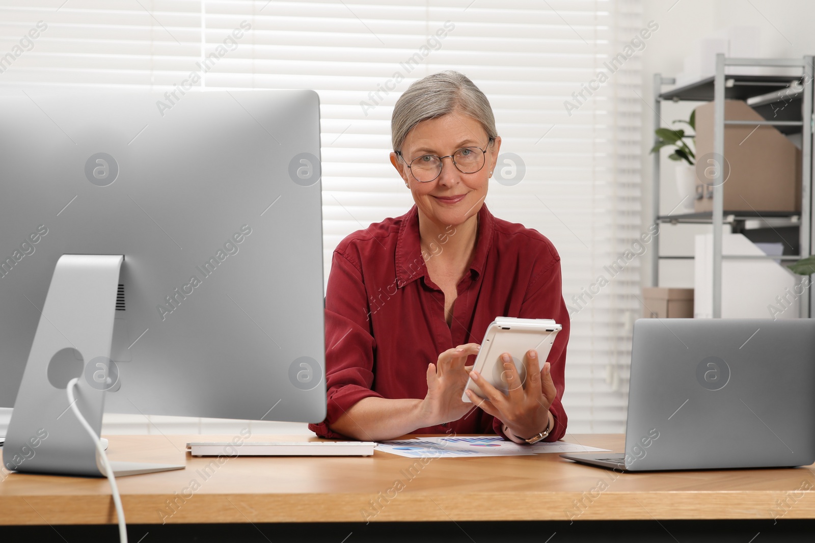 Photo of Senior accountant working at wooden desk in office