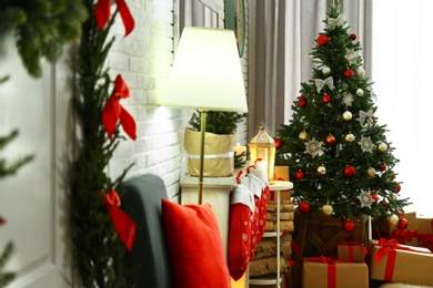 Stylish interior with beautiful Christmas tree and decorative fireplace