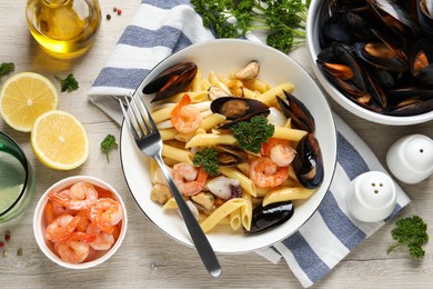 Delicious pasta with sea food served on white wooden table, flat lay