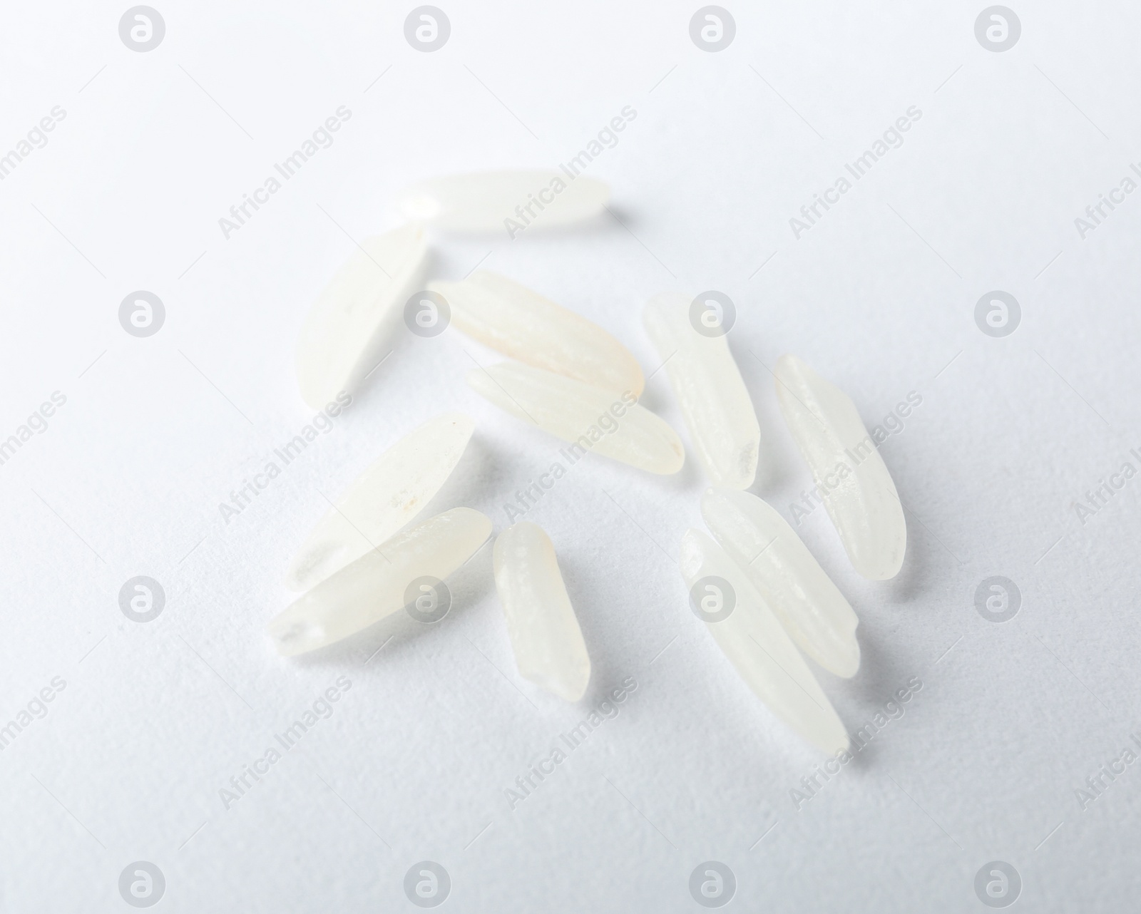 Photo of Uncooked long grain rice on white background, closeup