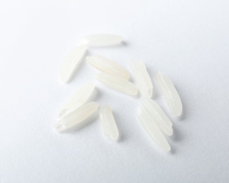 Photo of Uncooked long grain rice on white background, closeup