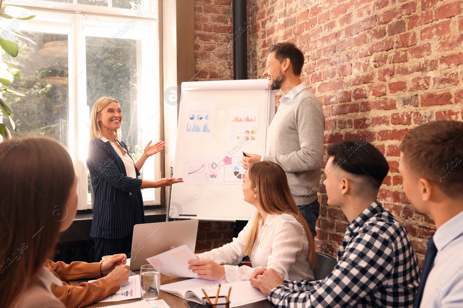 Photo of Businesswoman having meeting with her employees in office. Lady boss