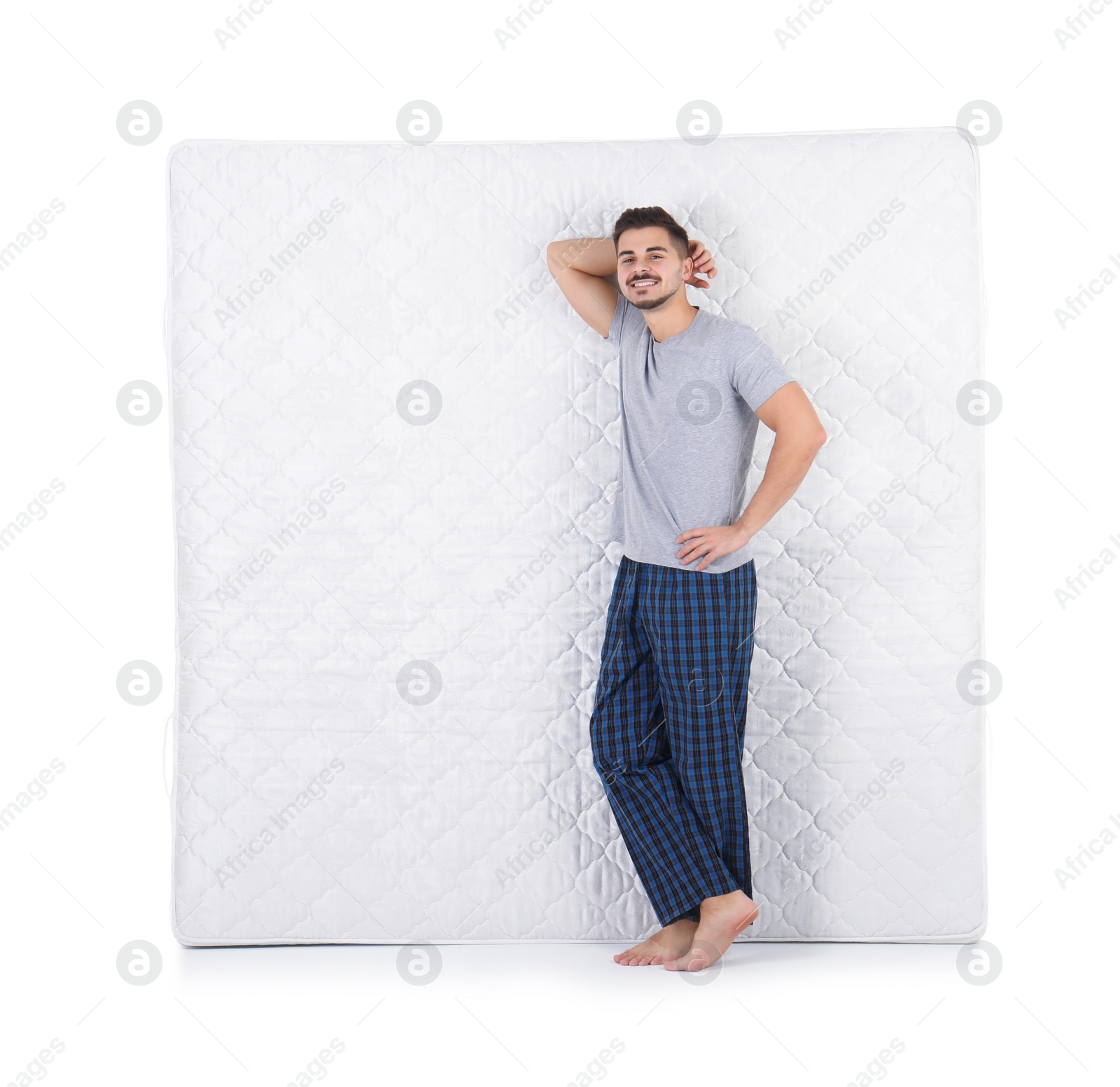 Photo of Young man with comfortable mattress isolated on white