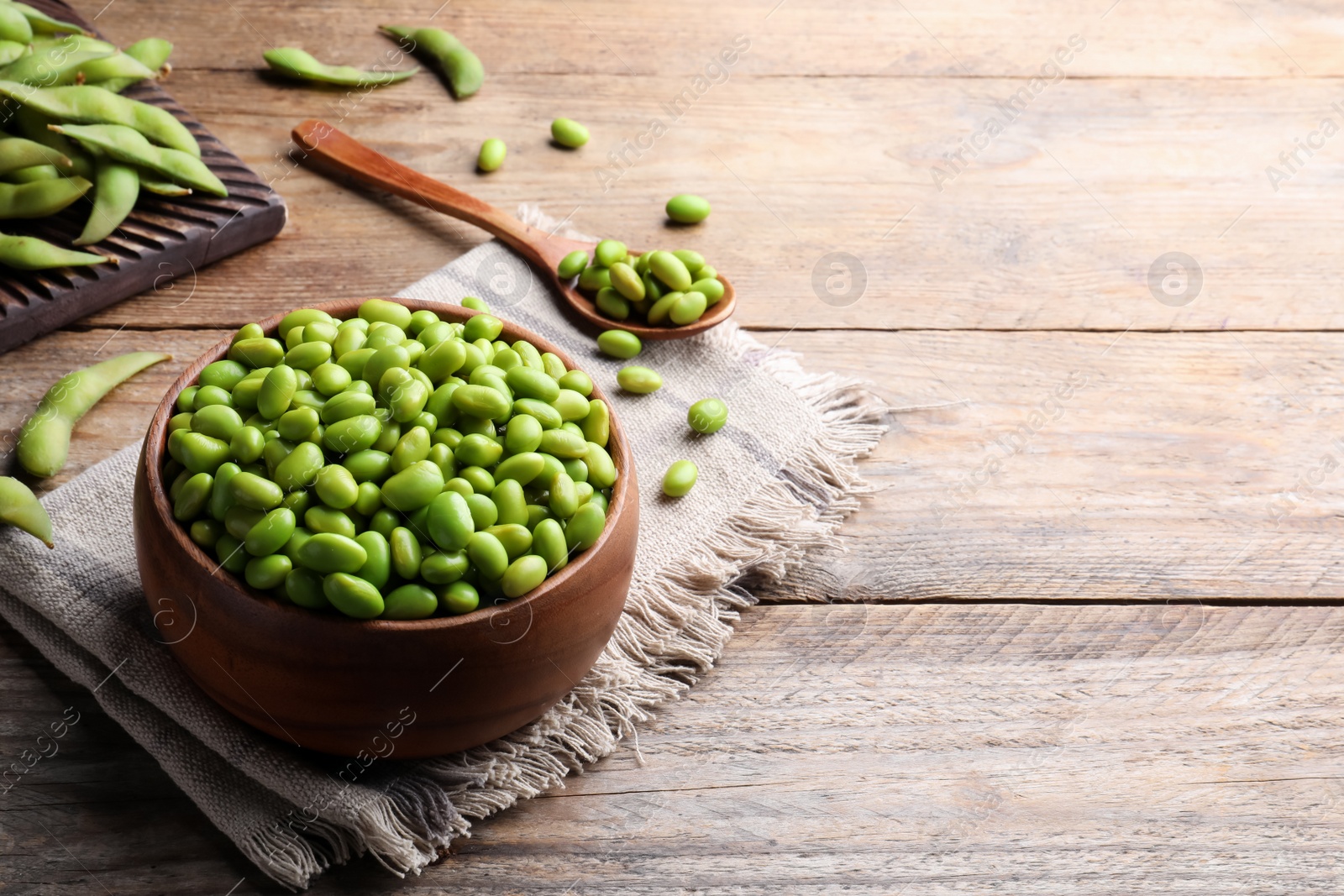 Photo of Delicious edamame beans on wooden table, space for text