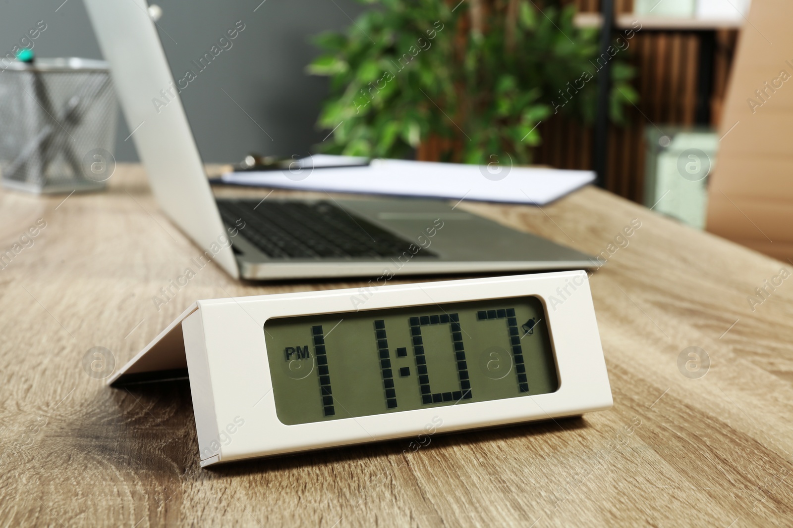 Photo of Digital clock on table in office. Time management