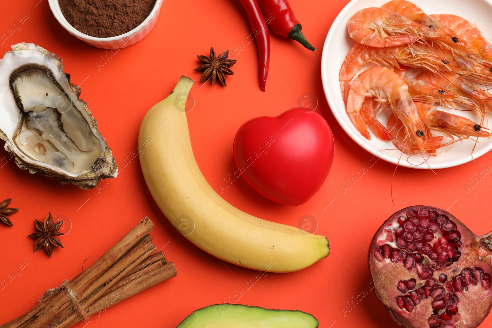 Photo of Natural aphrodisiac. Different food products and red decorative heart on orange background, flat lay