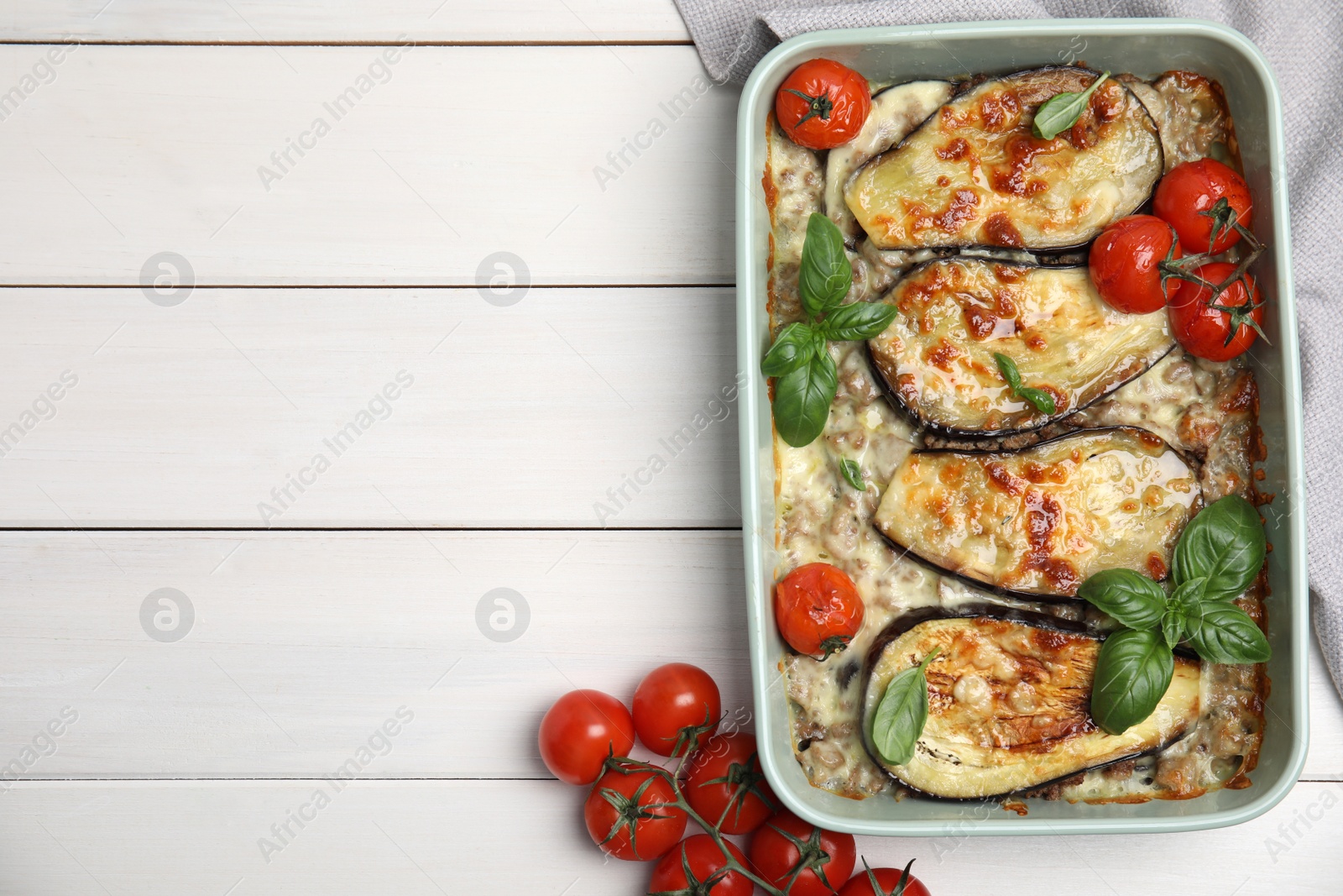 Photo of Delicious eggplant lasagna in baking dish on white wooden table, top view. Space for text