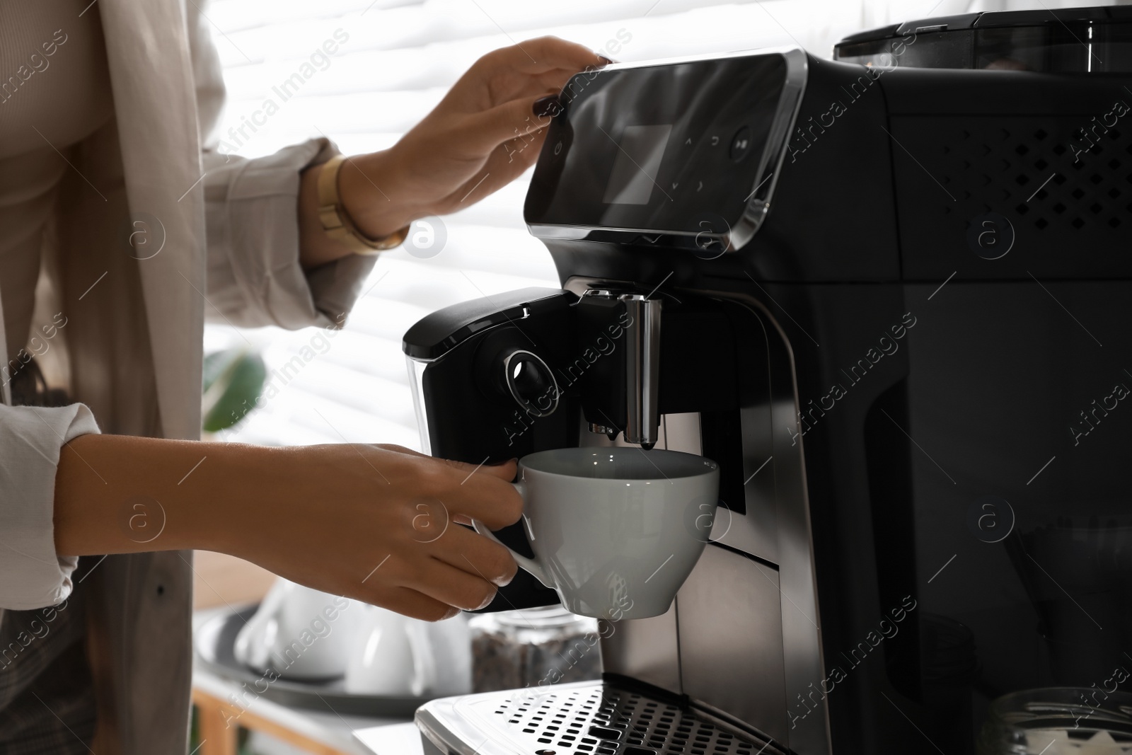 Photo of African American woman preparing fresh aromatic coffee with modern machine in office, closeup