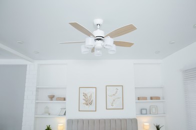 Photo of Ceiling fan with lamps in stylish bedroom, low angle view