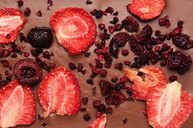 Chocolate bar with freeze dried strawberries and cherries as background, closeup