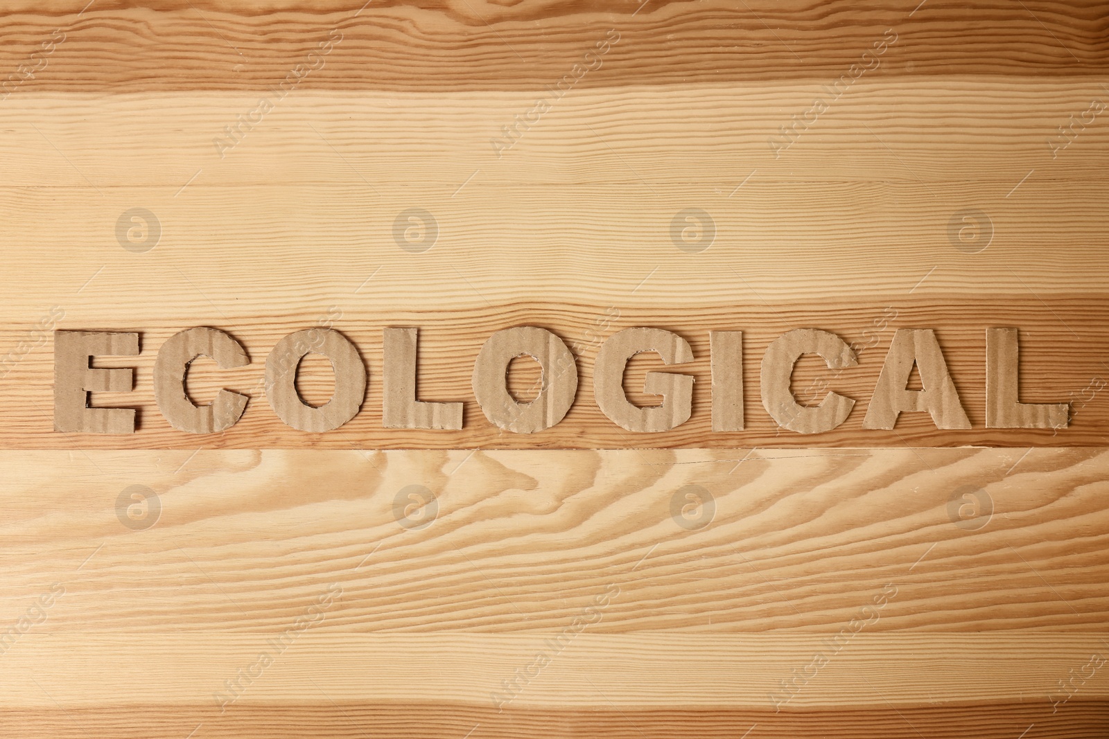 Photo of Word "Ecological" made of cardboard letters on wooden background, top view