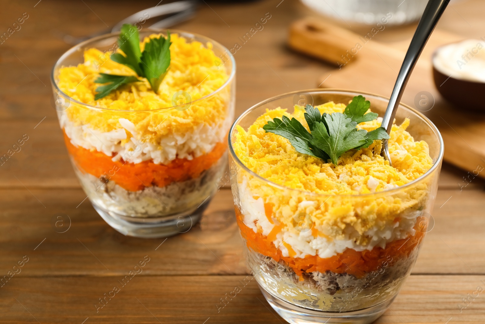 Photo of Traditional russian salad Mimosa served on wooden table