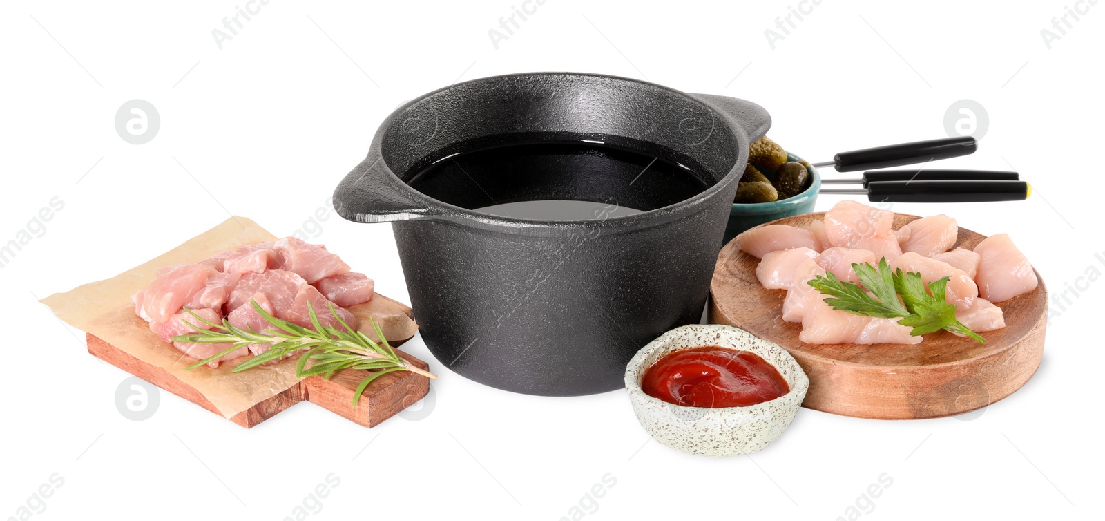 Photo of Fondue pot with oil, forks, raw meat pieces and other products isolated on white