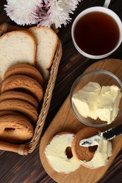 Photo of Tasty homemade butter, cookies and tea on wooden table, flat lay