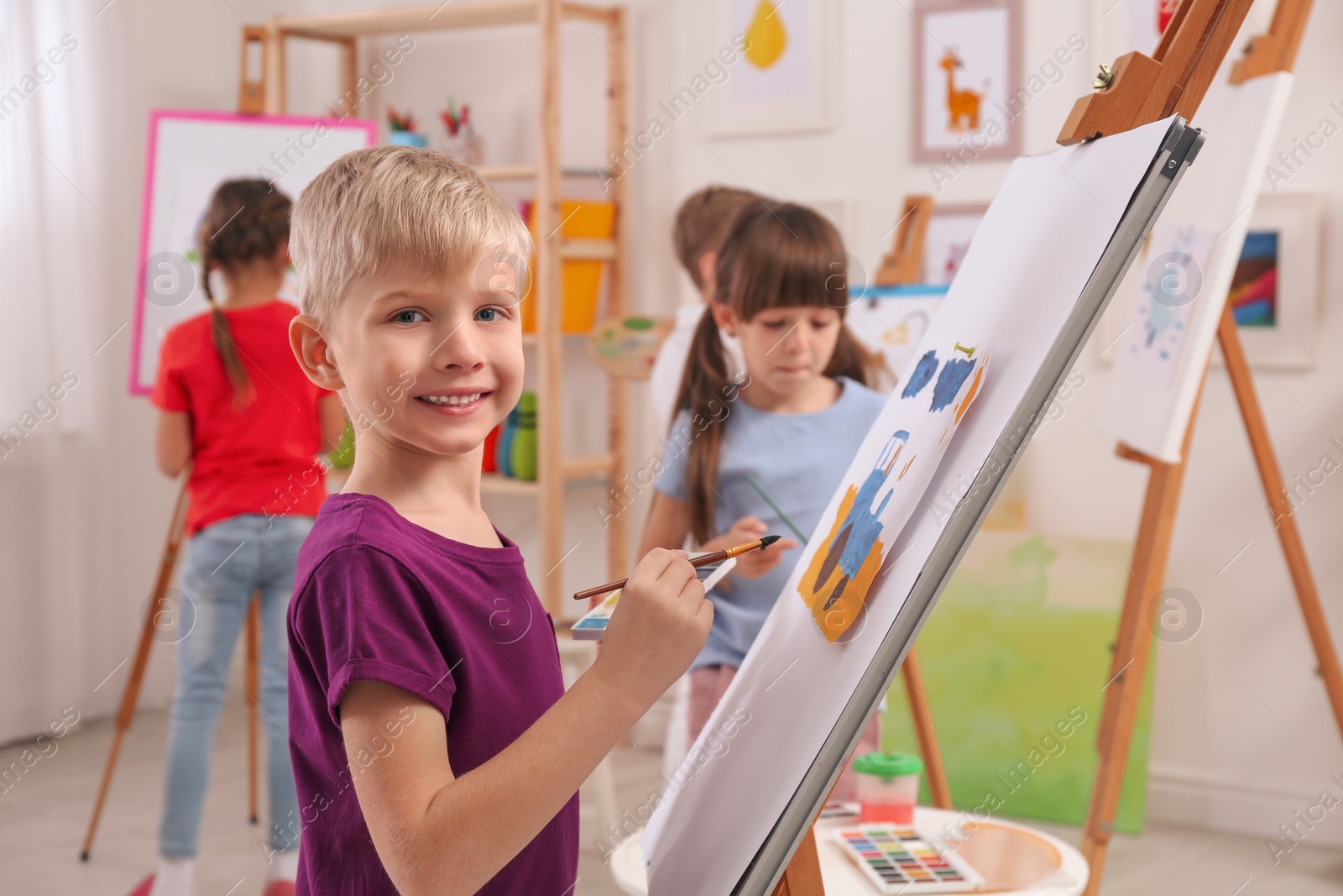 Photo of Cute little child painting during lesson in room