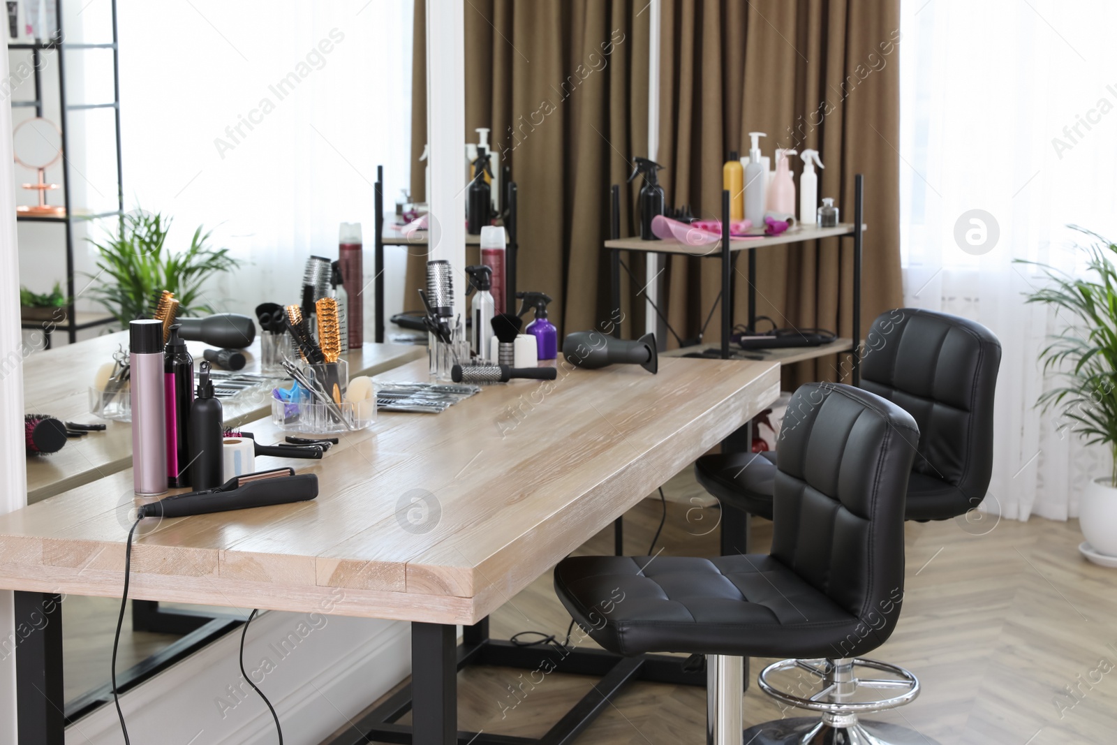 Photo of Stylish beauty salon interior with hairdresser's workplace