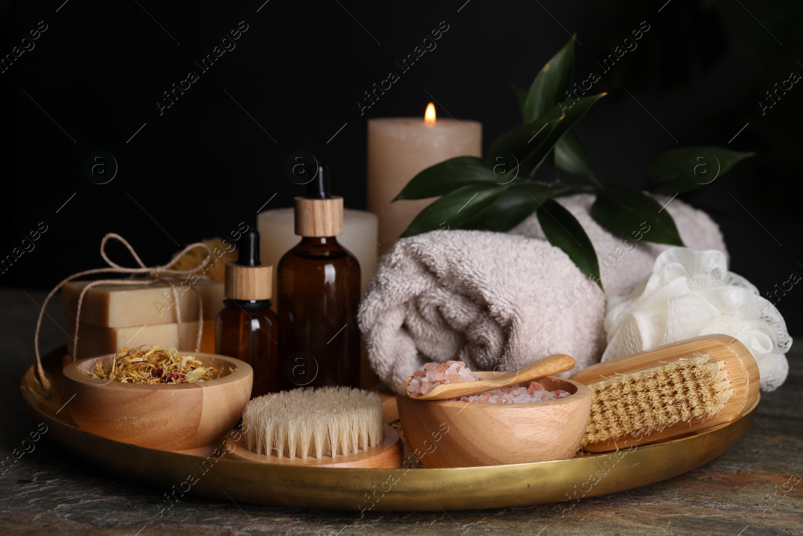 Photo of Spa composition. Brushes, bottles and sea salt on grey textured table