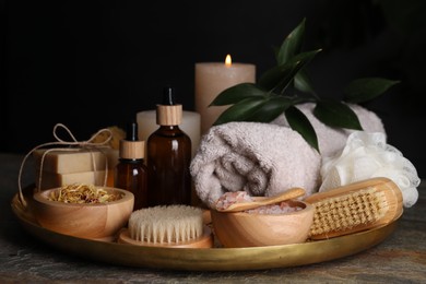 Photo of Spa composition. Brushes, bottles and sea salt on grey textured table