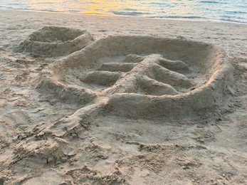 Palm tree made of sand on beach