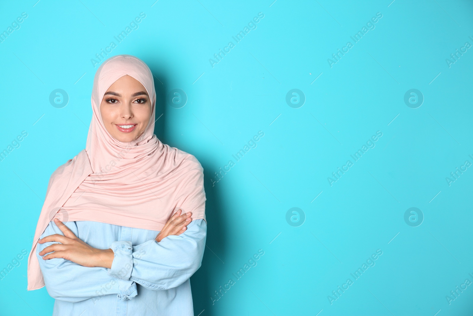 Photo of Portrait of young Muslim woman in hijab against color background. Space for text