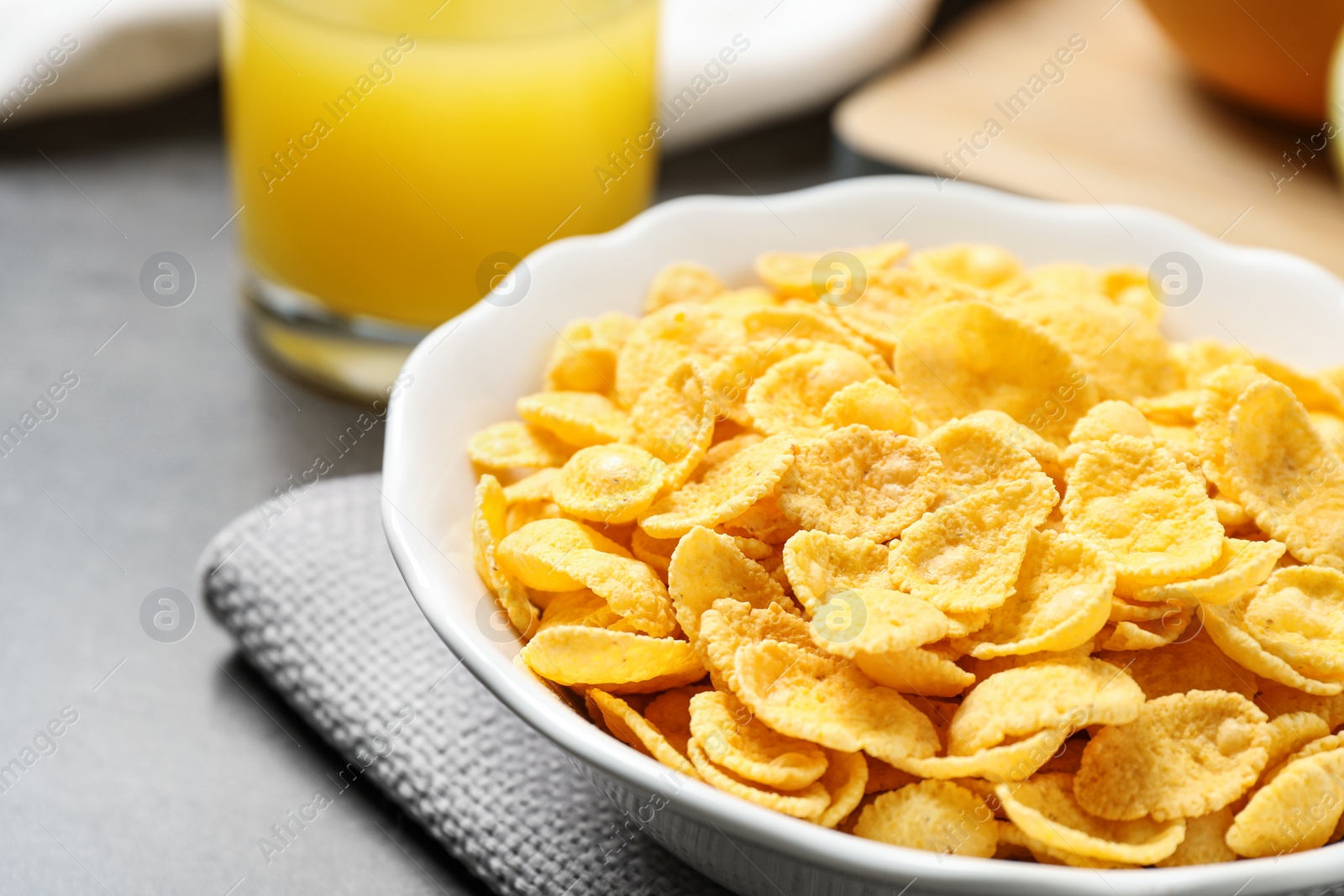 Photo of Tasty corn flakes on grey table, closeup